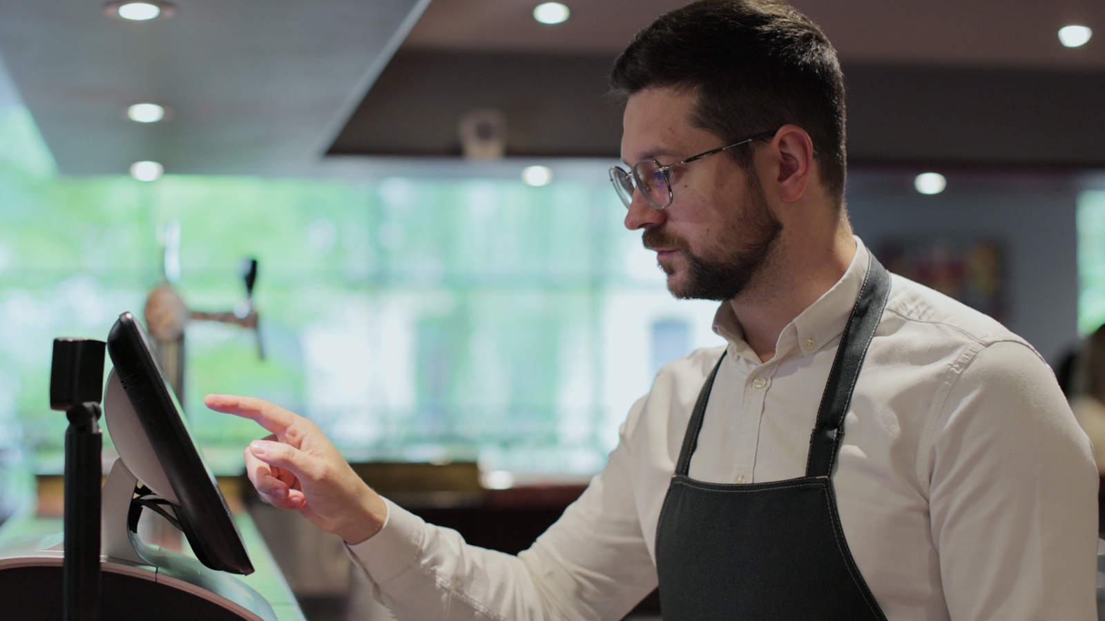 Trabajador de un restaurante usando una pantalla táctil de punto de venta