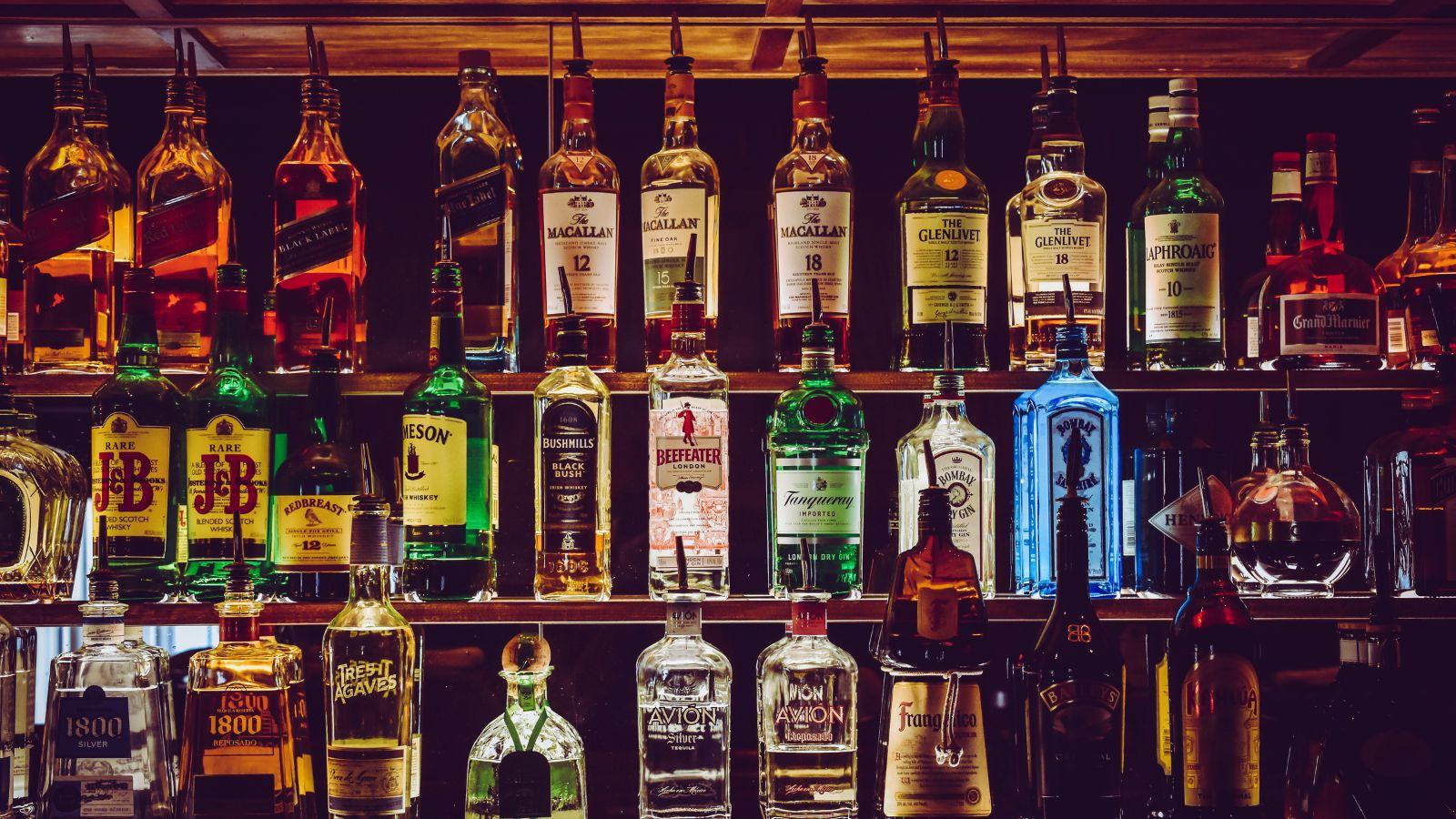 Botellas de licor ordenadas en las repisas de la barra de un restaurante